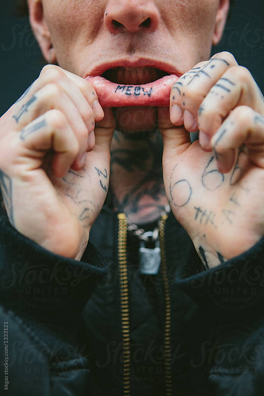 Tattooed man shows tattoo inside his lip