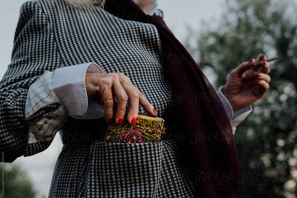 Detail of woman keeping her cigarette case in her jacket pocket in flamenco attitude