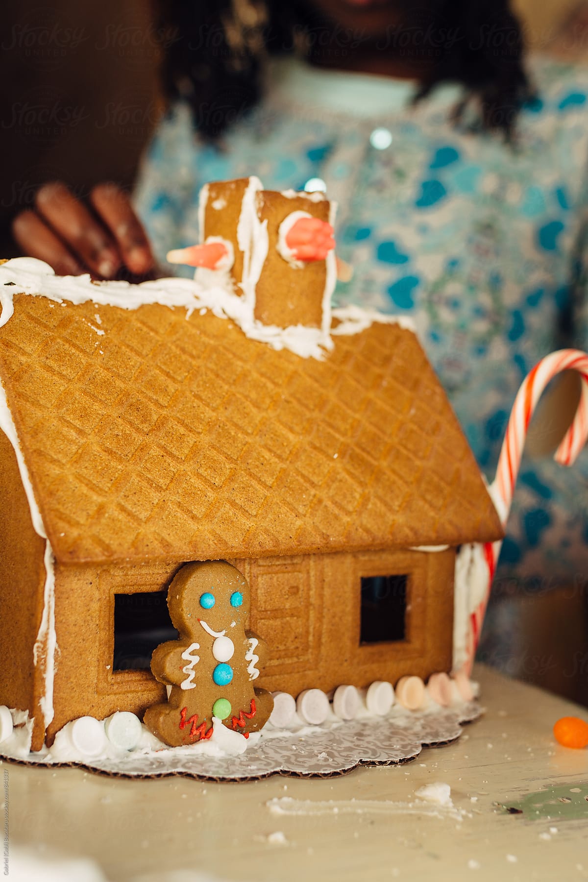 Black girl building a gingerbread house