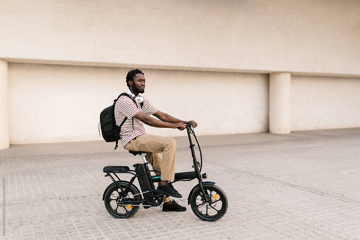 Black man riding electric bike on university campus