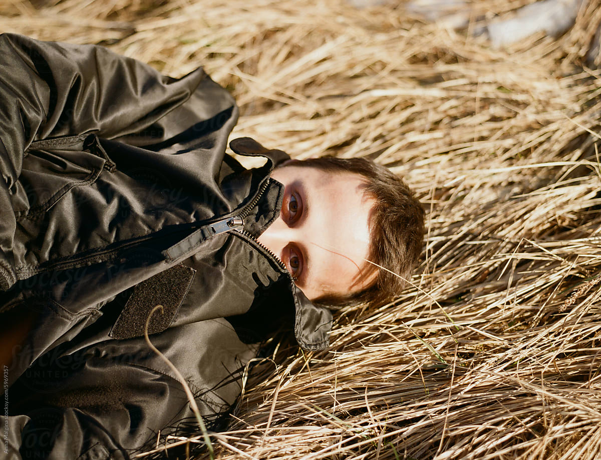 Young Man Lying in Golden Hay on Sunny Day