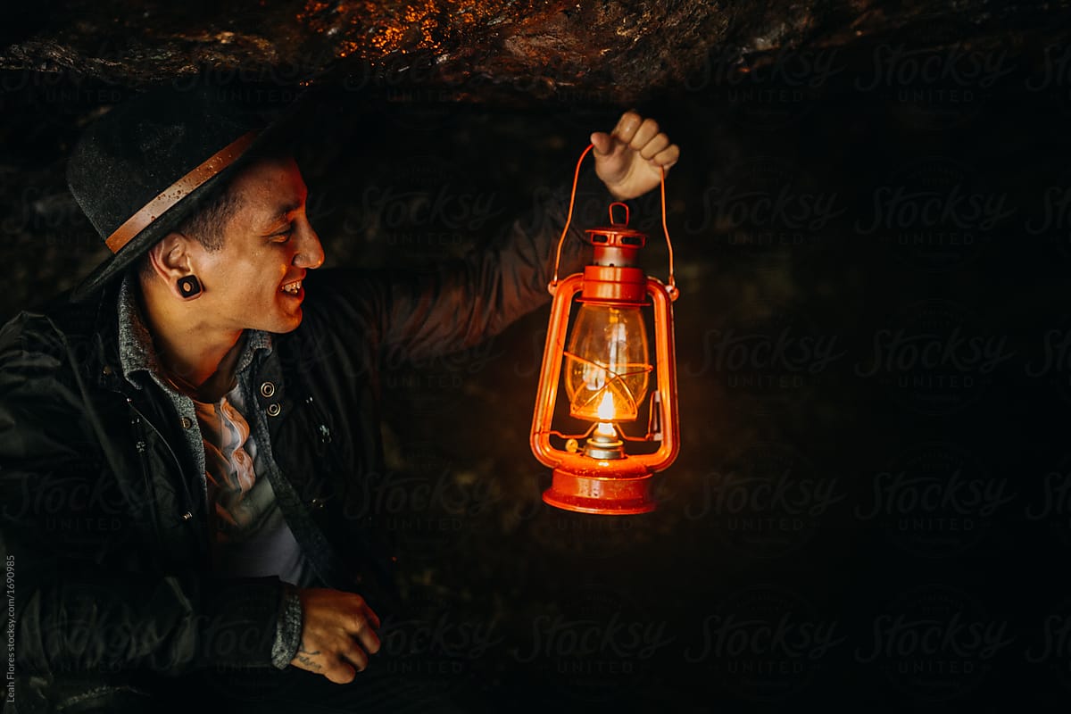 Man Holding Lantern in Cave