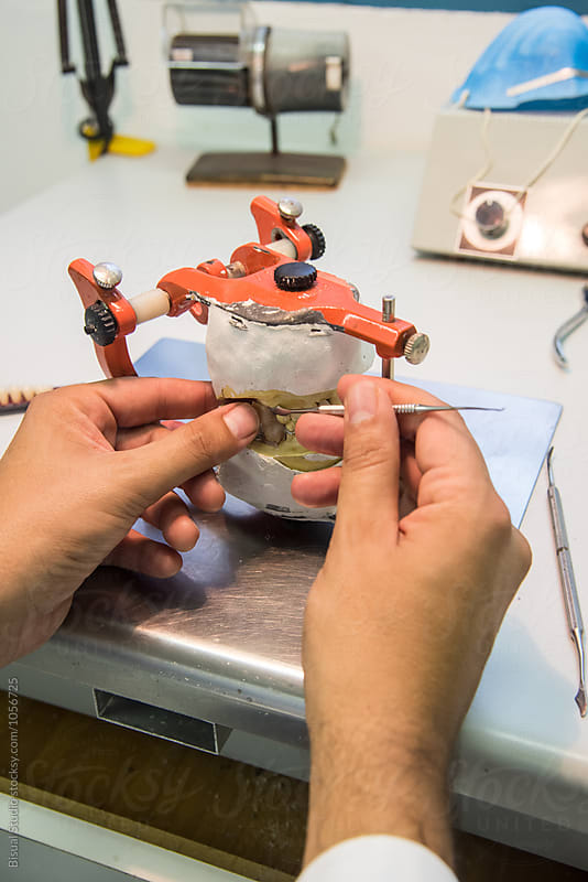 Dental Technician making handmade dental prosthesis in a work shop