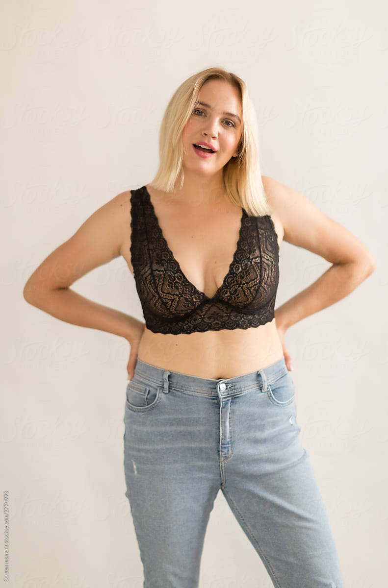 Portrait of a beautiful blonde woman in black bra on a white background. Beautiful blonde  plus size  woman  smiling