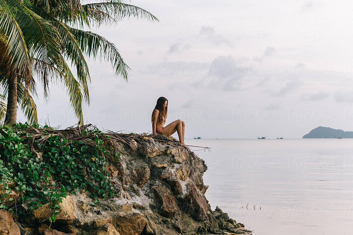 Woman Sitting On Rocks At The Beach By Stocksy Contributor Andrey