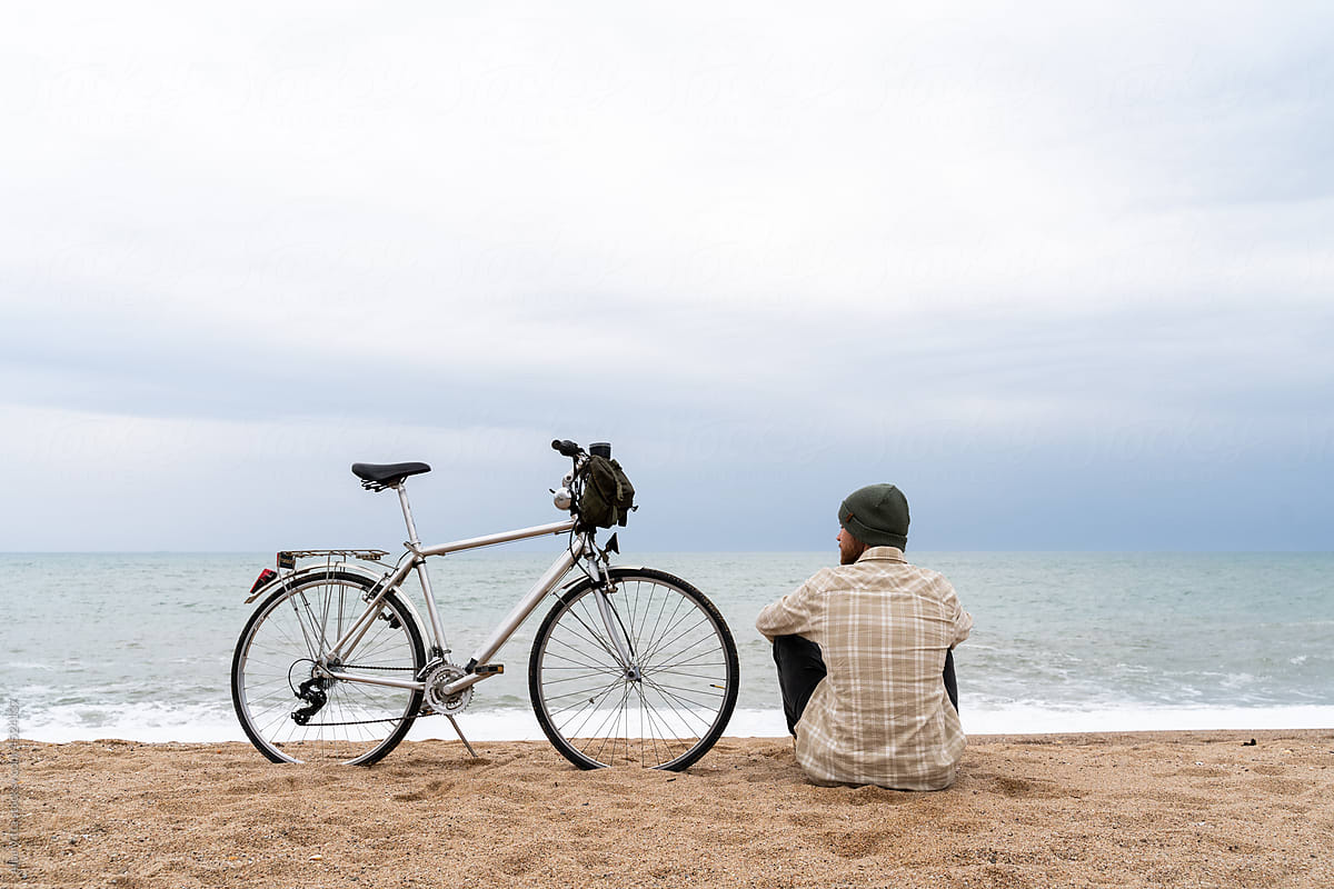 Man overlooking the sea with bike parked
