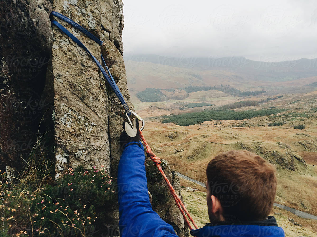 Mountaineer setting up sling for an anchor point.