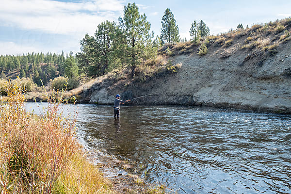 A Man Fishing In The Middle Of A River by Stocksy Contributor David  Keller - Stocksy