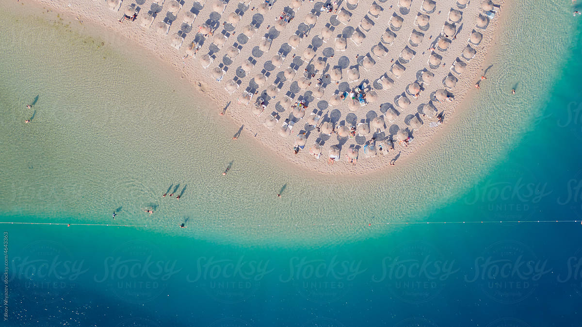 drone aerial photo of a sandy beach with azure water, paradise resort