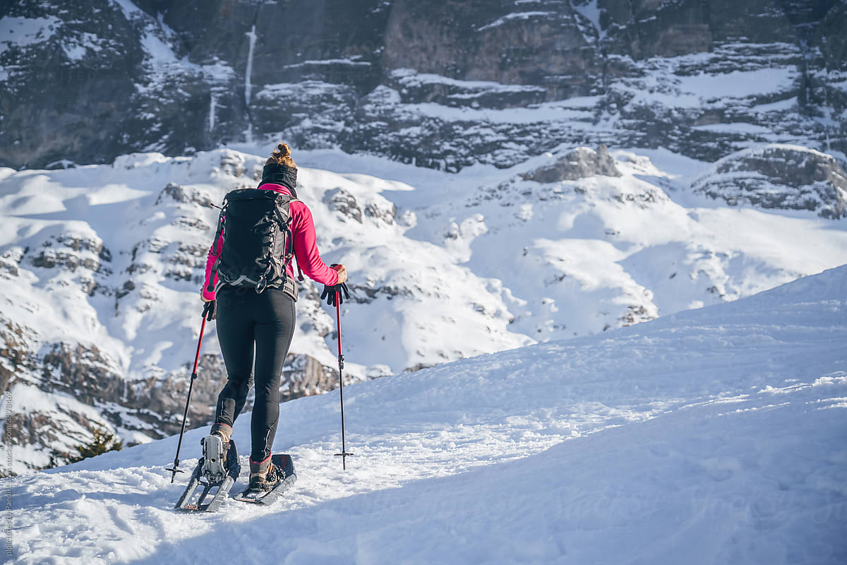 Girl with backpack on winter hike in the alps.