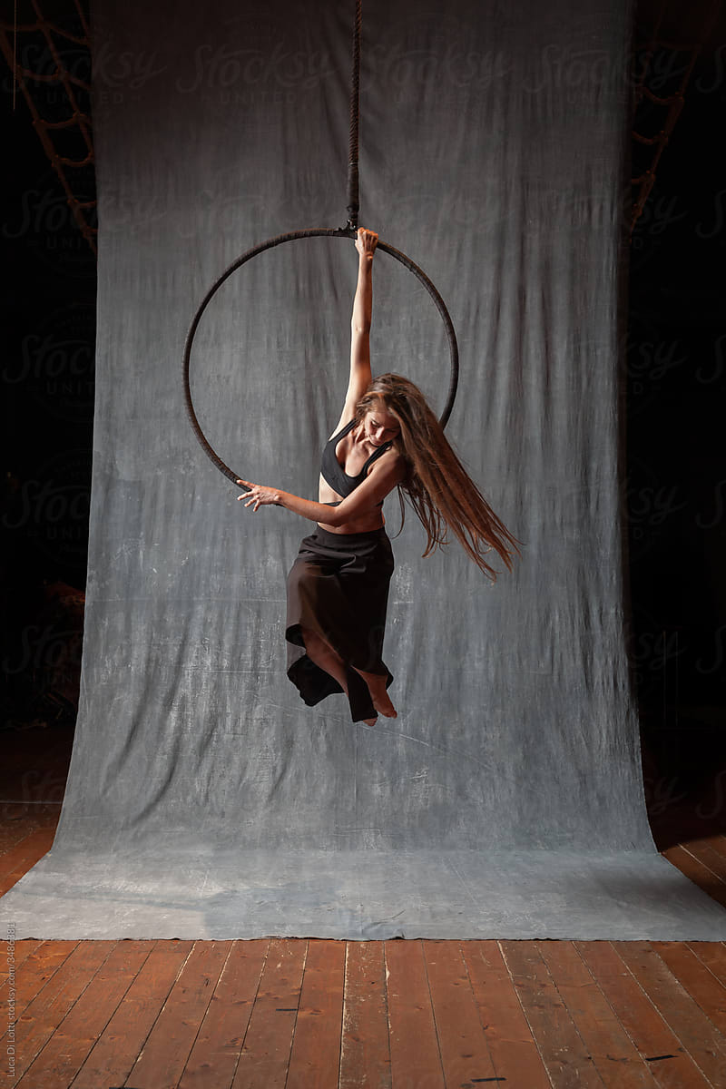 elegant pose of a circus aerialist on a Lyra or Aerial hoop