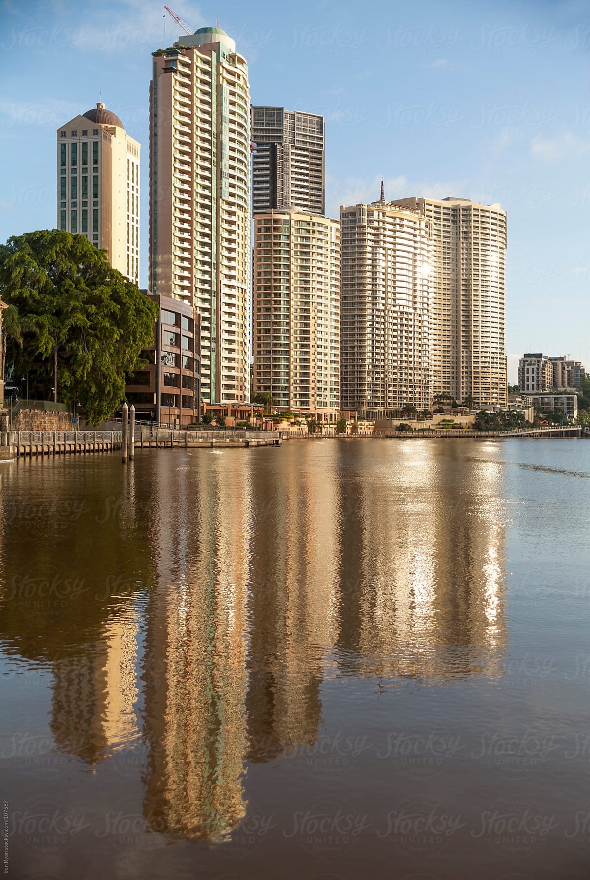 Waterfront apartments reflected in river at sunrise