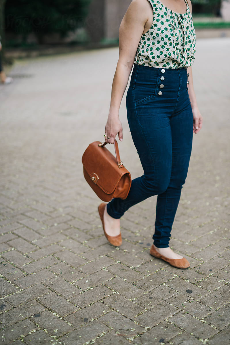Stylish young woman walking with her purse