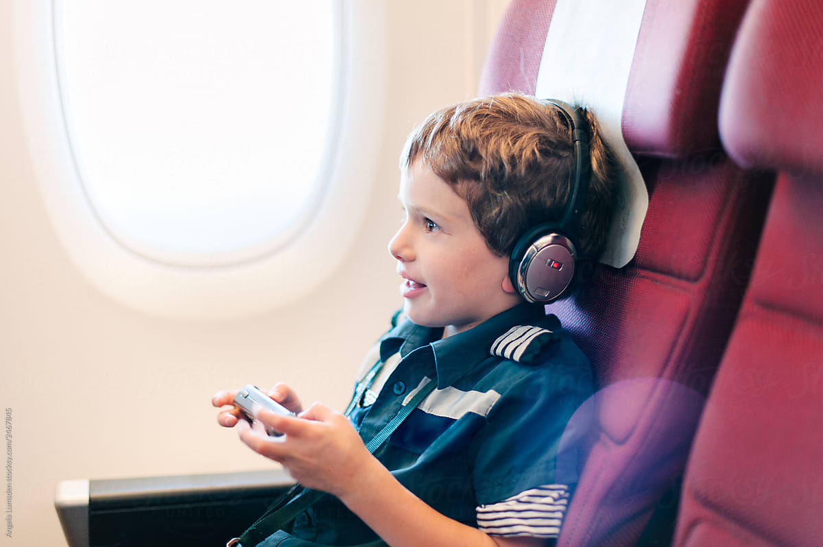 Boy playing an electronic game on an airplane