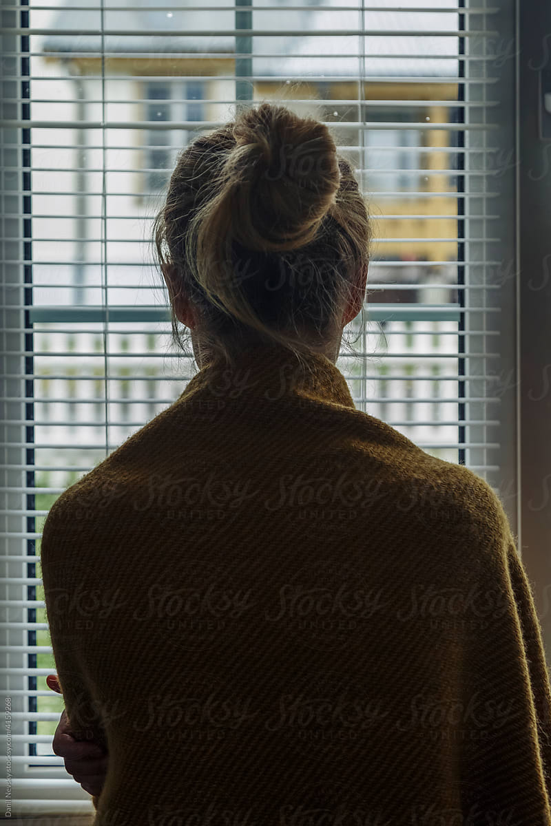Depressed woman against window