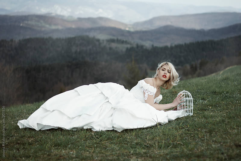 Woman In A Wedding Dress Lying On Grass By Jovana Rikalo Stocksy United