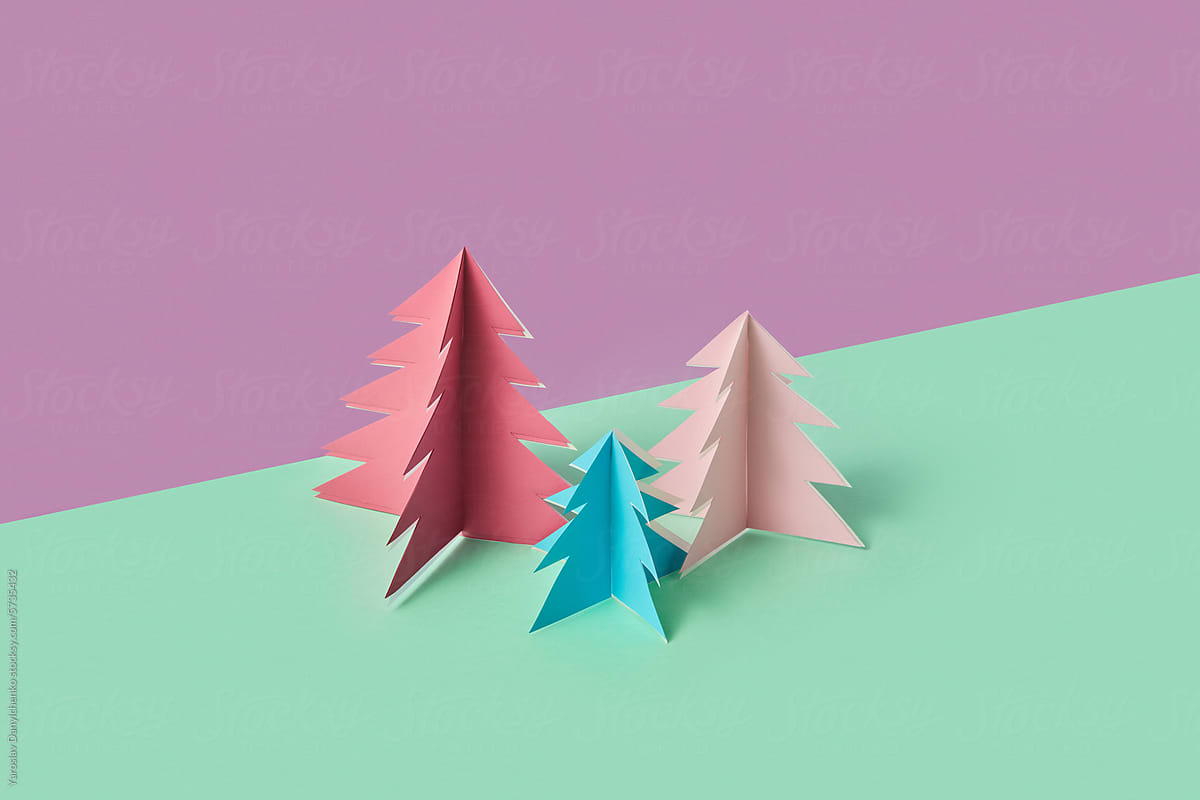 Colorful papercraft Christmas trees over duotone background