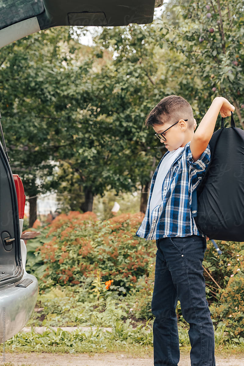 Teen Boy Throwing School Bag into Car, Starting New School Year