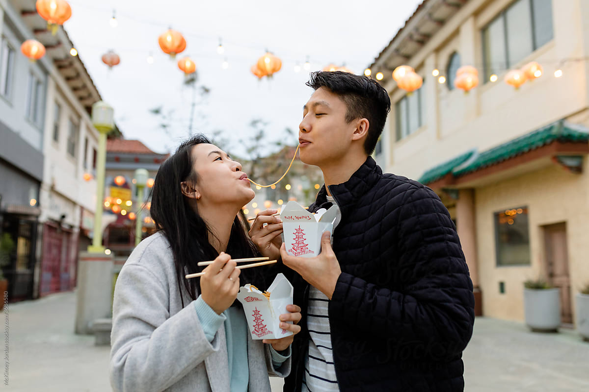 Happy Asian Couple Shares a Noodle