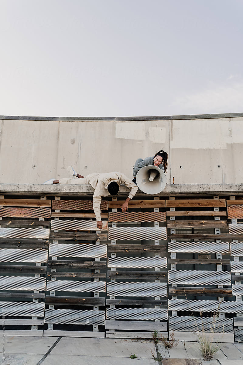 Woman talking on megaphone on top of wall