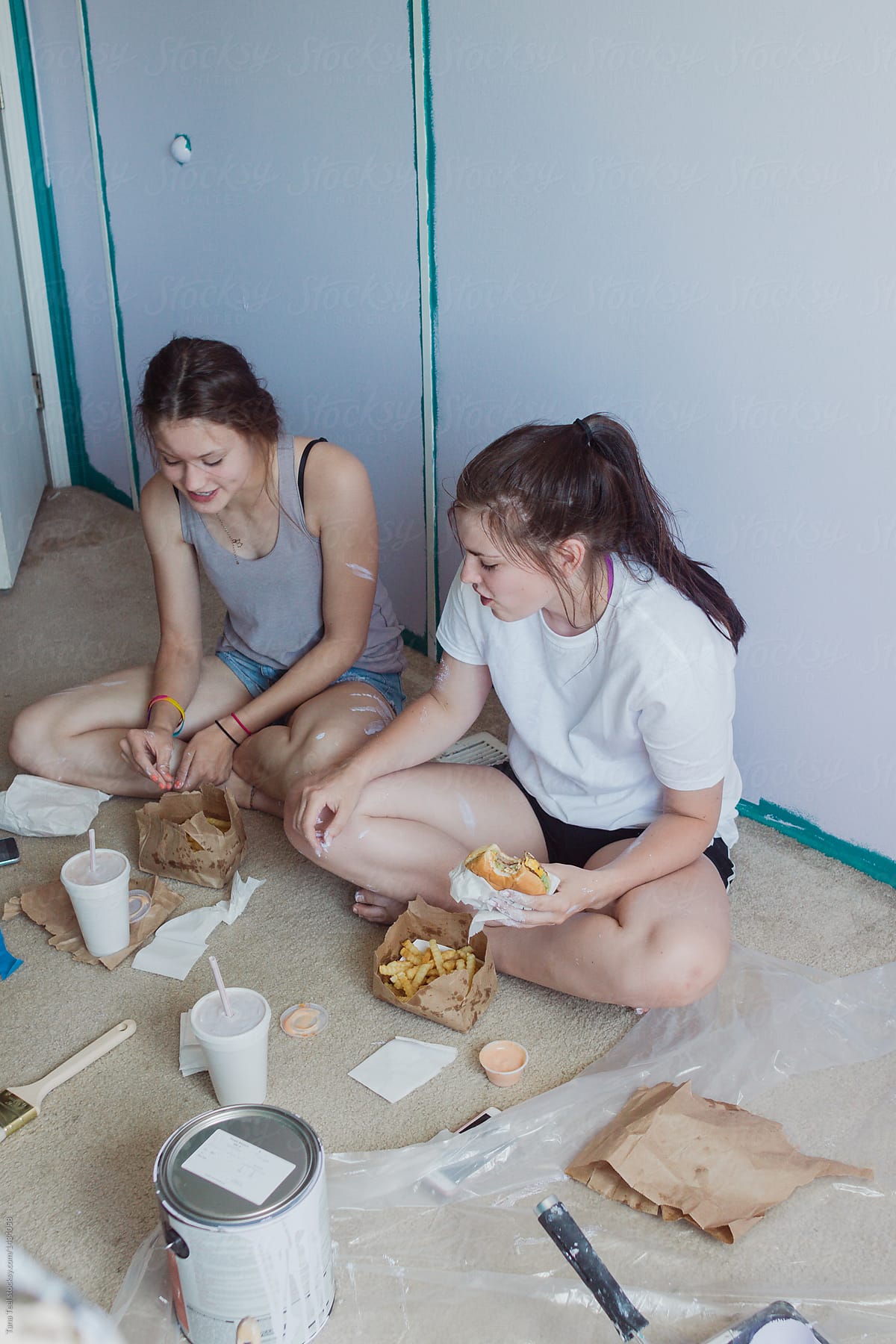 teenagers taking a lunch break while painting a bedroom