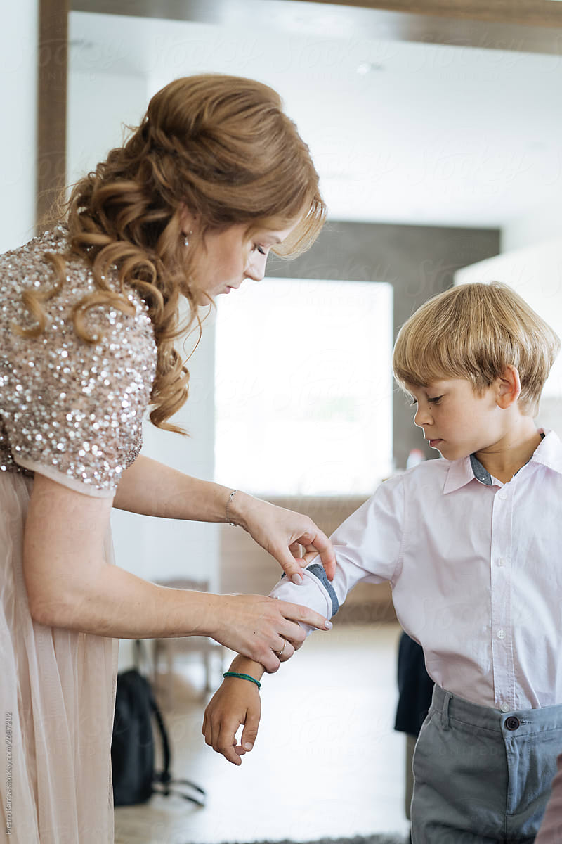 Mother dressing up son before party
