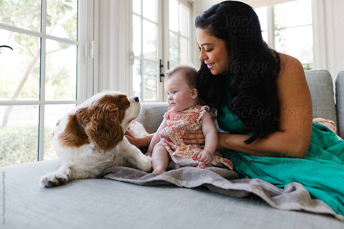 A baby girl and mother with a dog