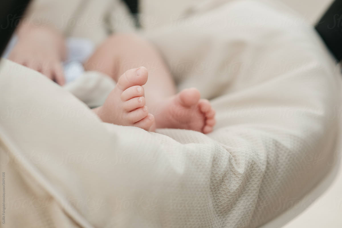 Adorable baby feet in a portable crib.