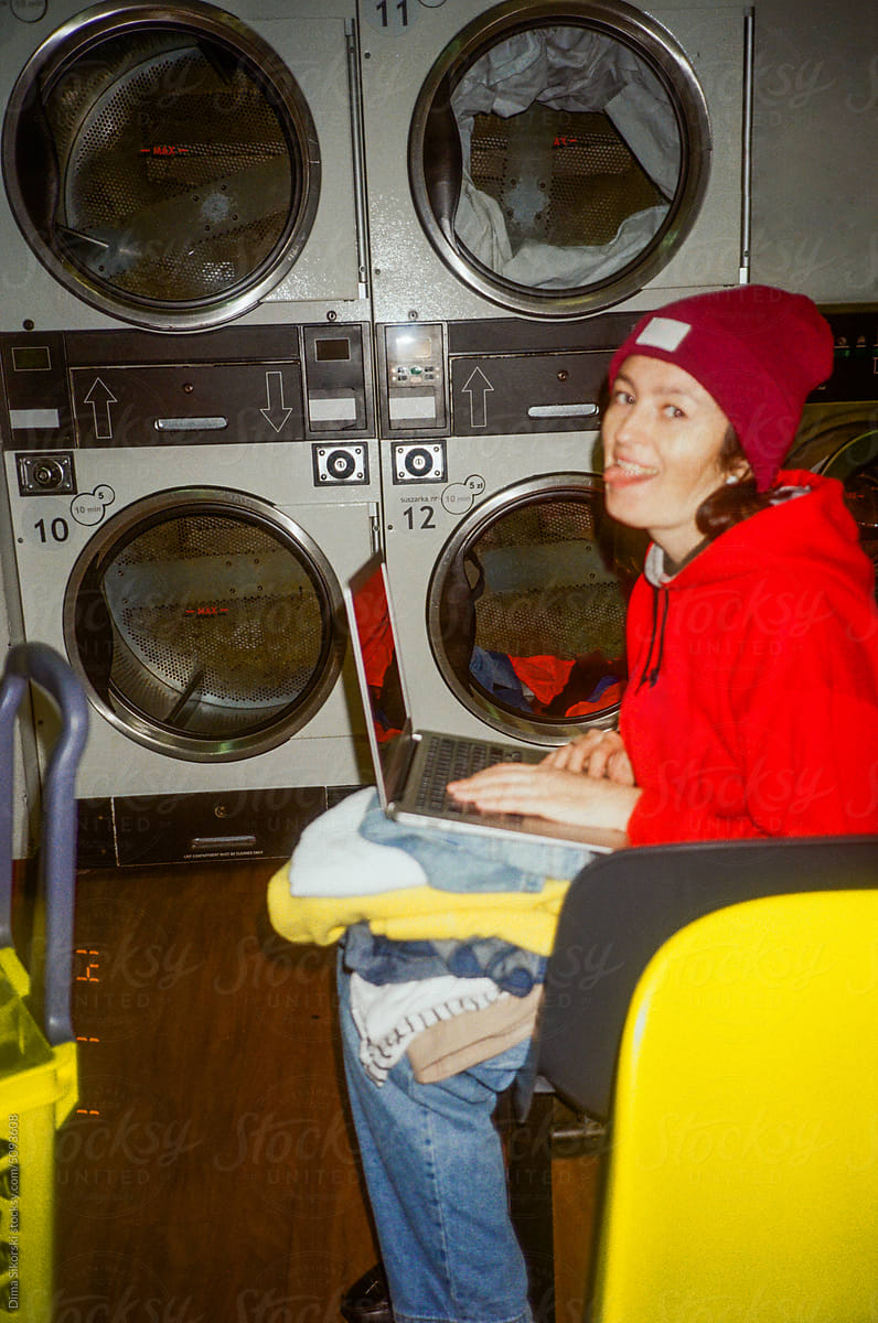 Amateur shot of a waiting girl making a funny grimace in a laundromat