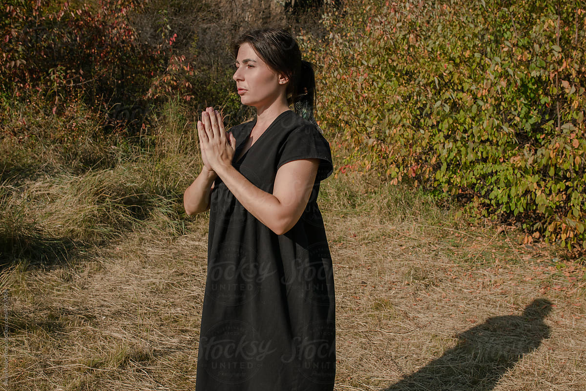 Namaste gesture with folded arms at chest during outdoor practice