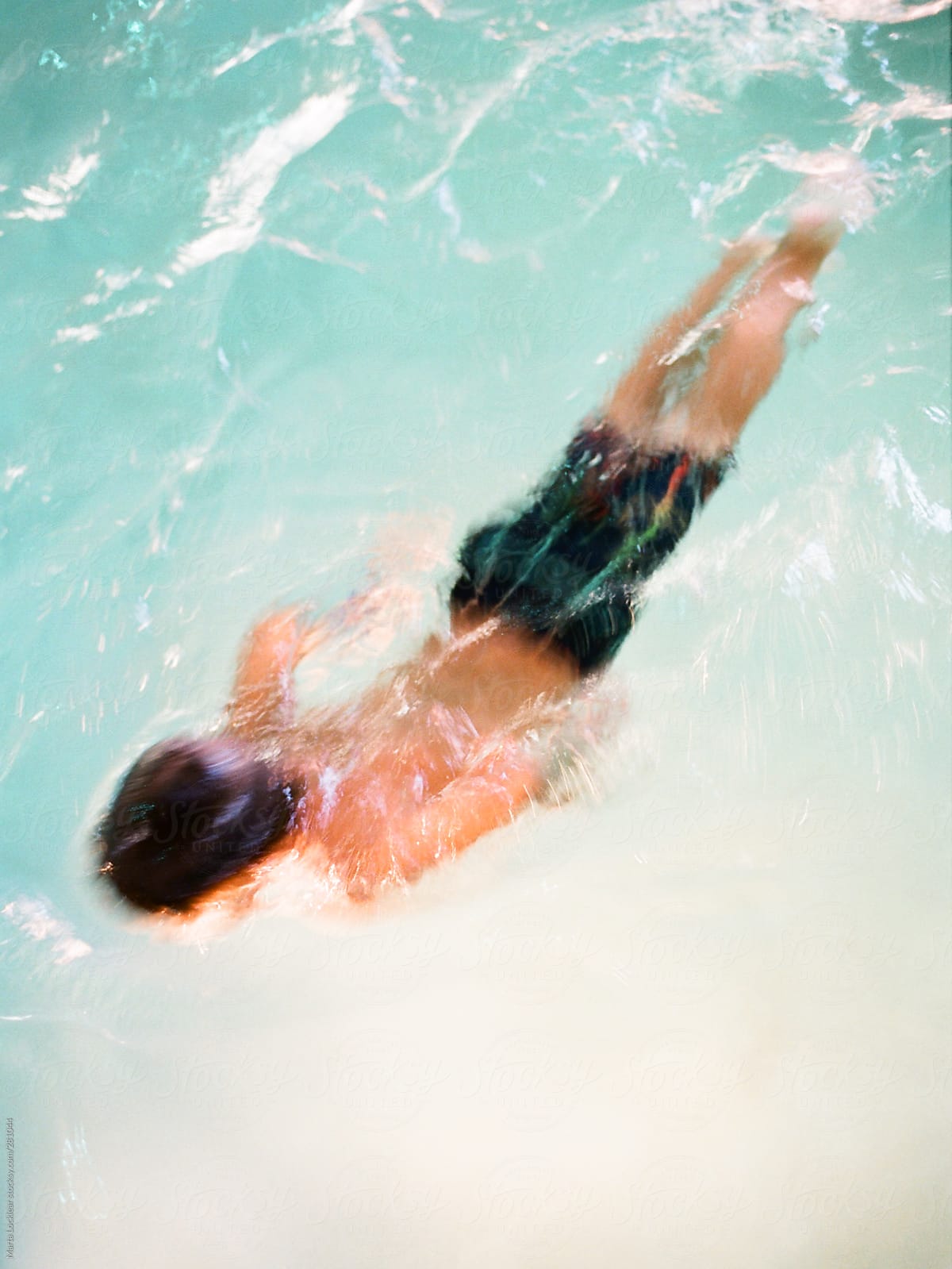 Boy swimming in a pool near the pool light