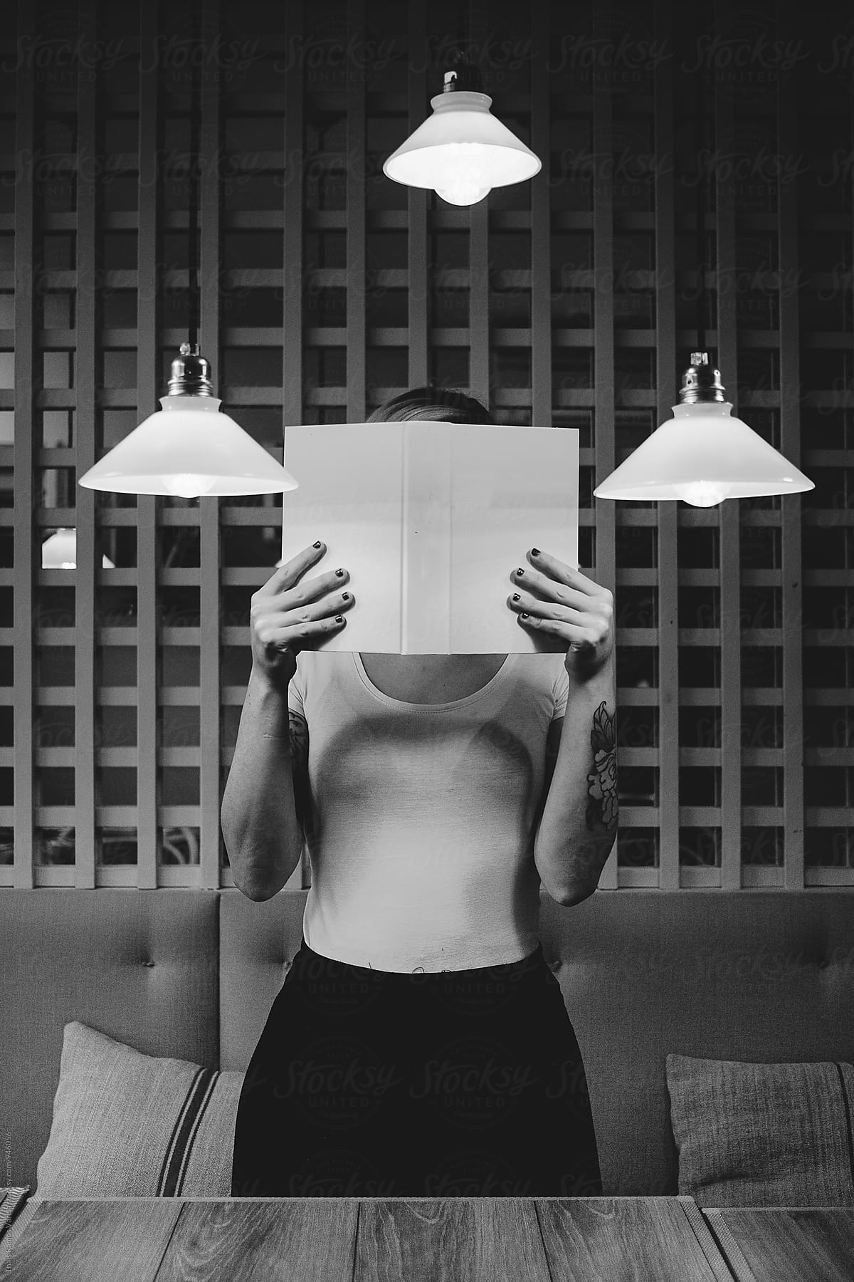 Woman Hiding Her Face With A Book By Stocksy Contributor Thais Ramos Varela Stocksy
