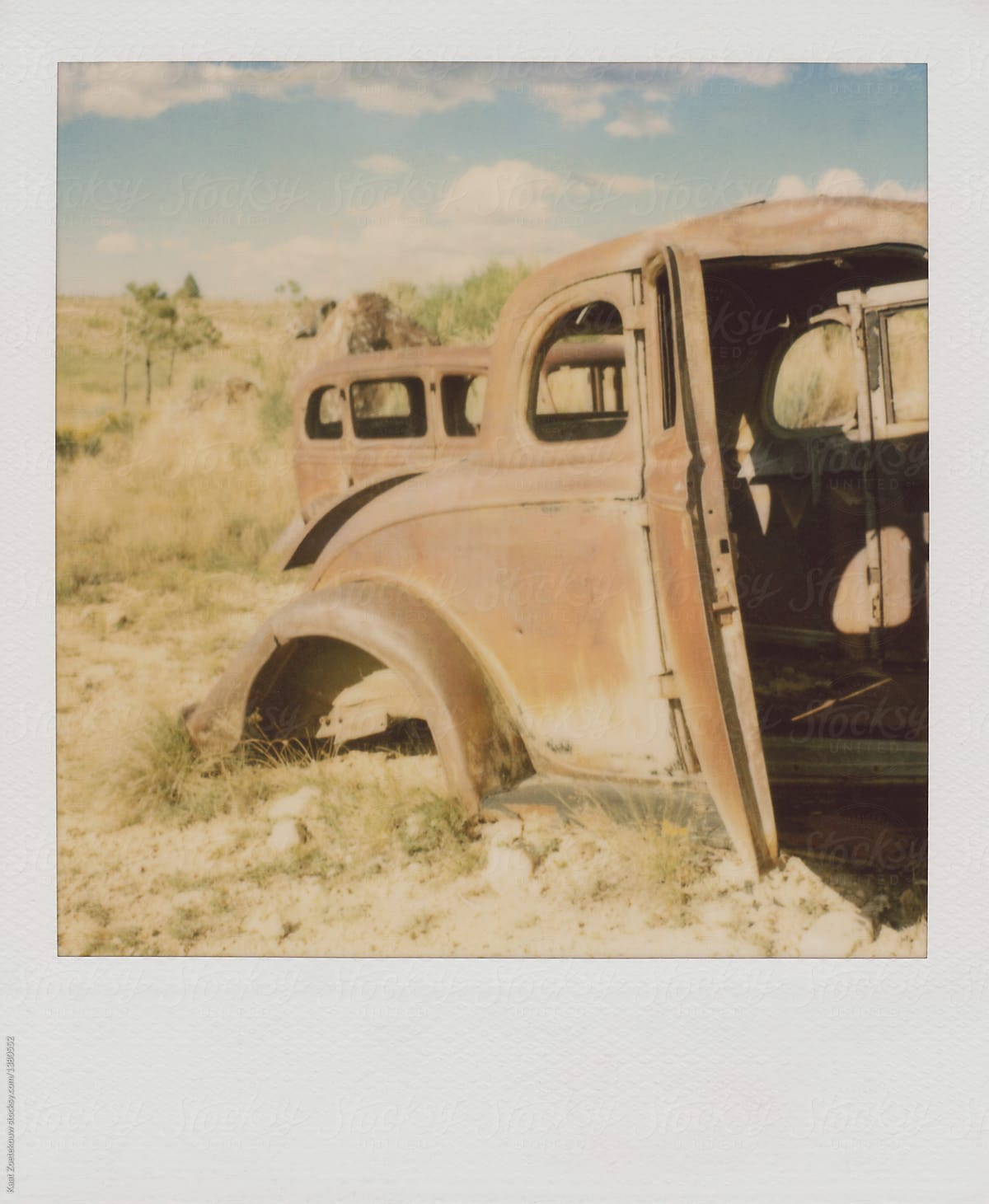 Polaroid image of old, rusted American cars