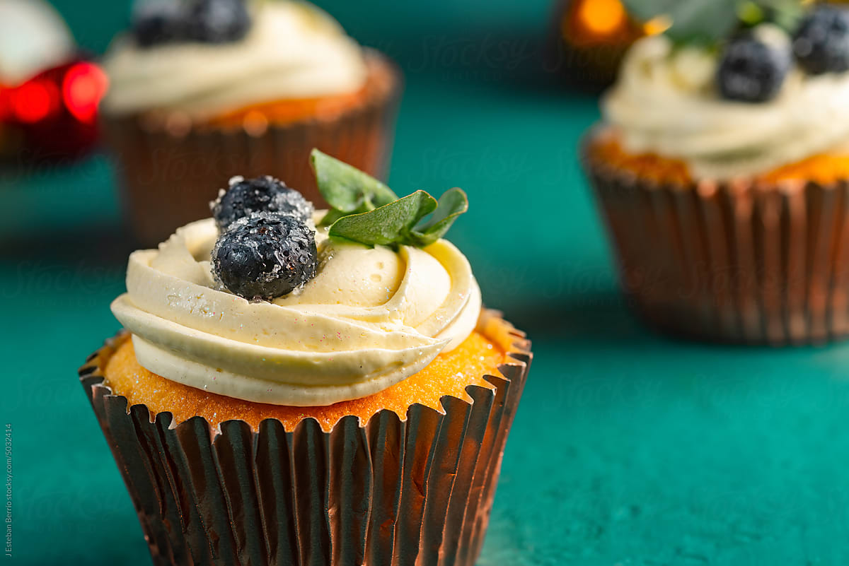 Cupcake with cream, blueberries and edible leaves