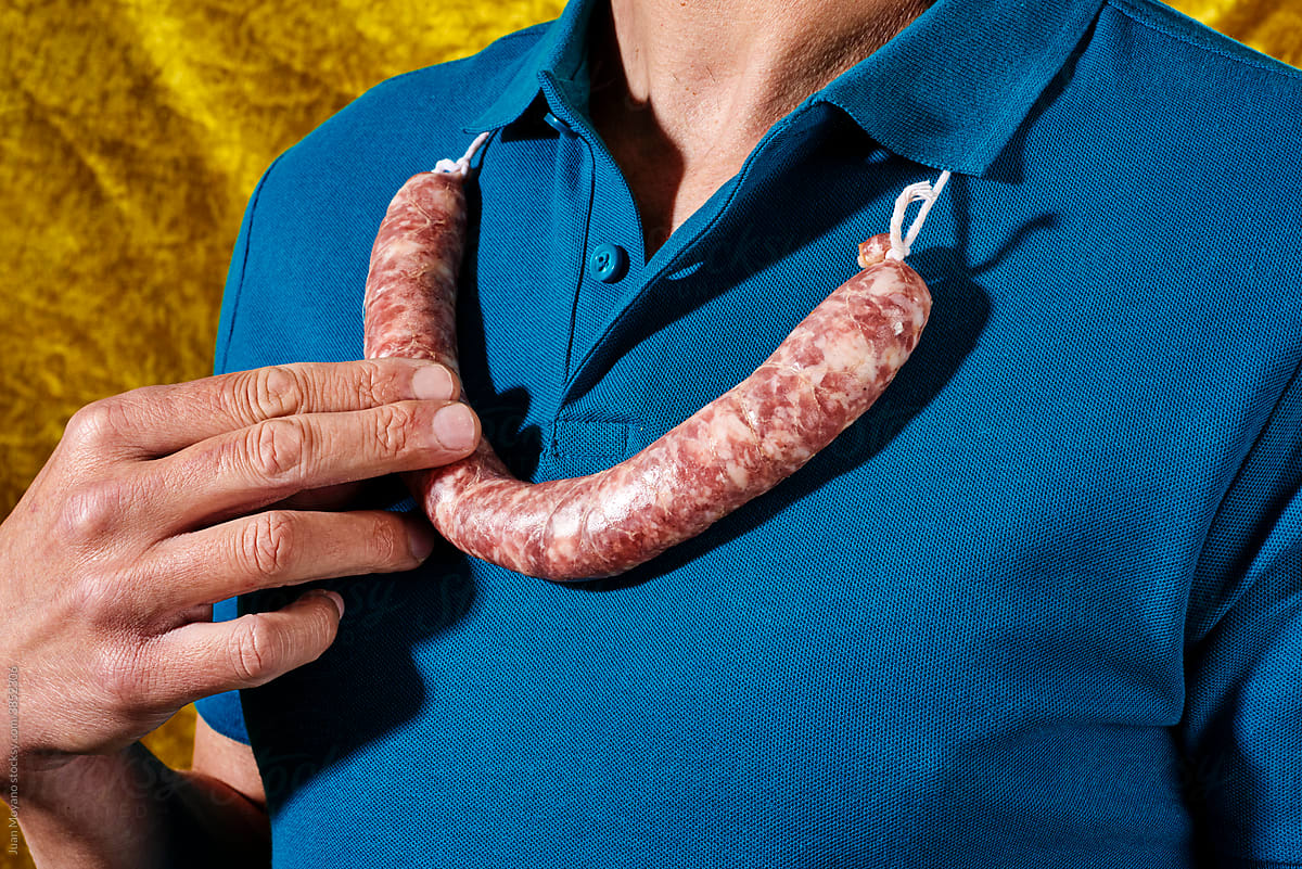 young man wears a raw pork sausage in his neck