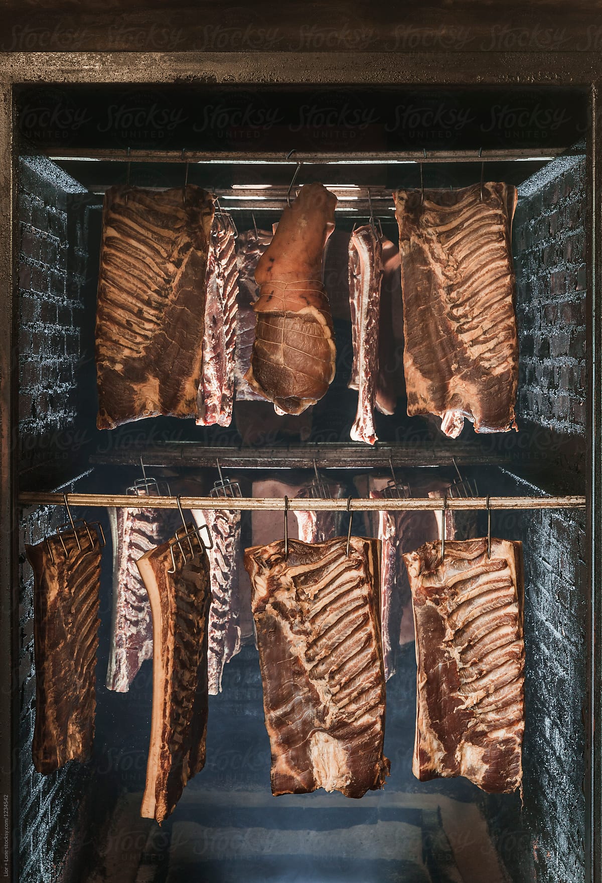 Dried aged bacon and lomo hanging in a smoking chamber