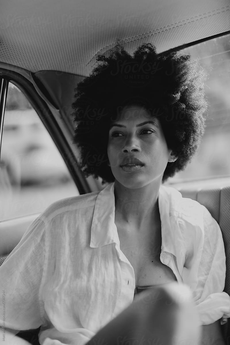 Black Woman sitting in the back of a White Vintage Car