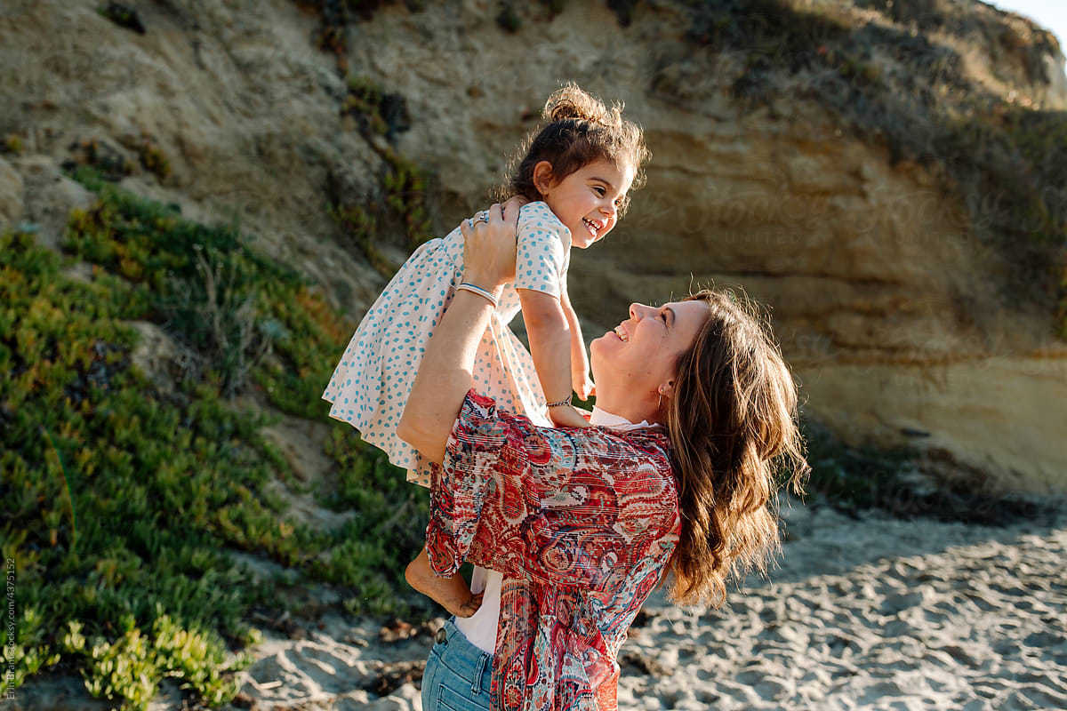 Mom holds happy daughter in the air
