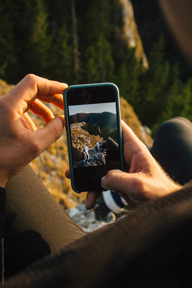 Taking a photo on a mountain cliff edge