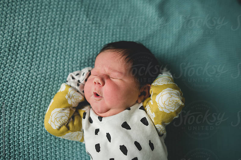 Newborn baby making face while stretching