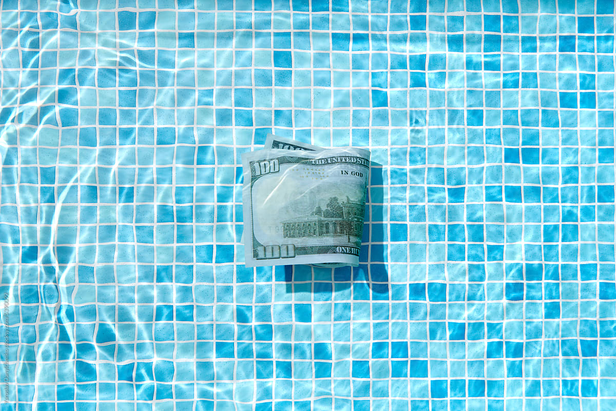 100 dollar bill in cool swimming pool water.