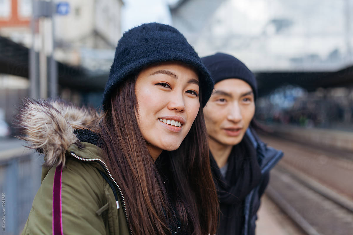 Asian couple on a train station in winter
