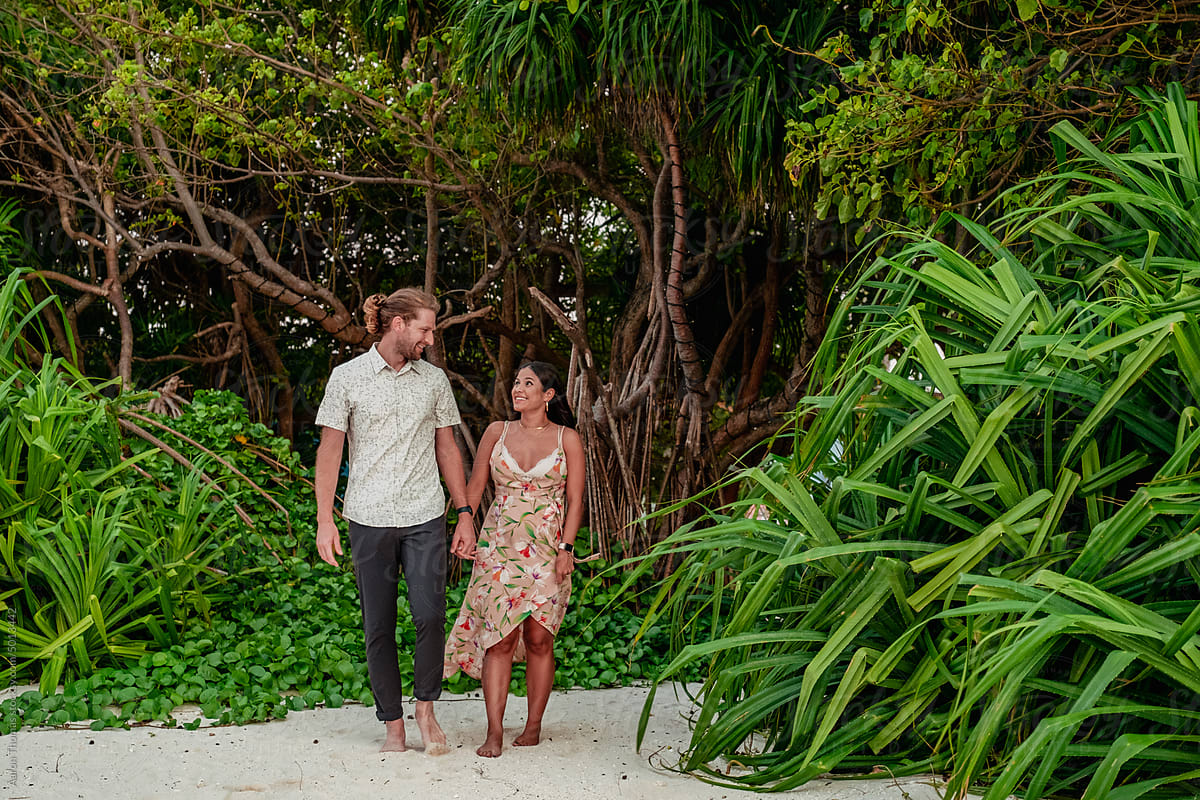 Couple walking alongside Maldive beach