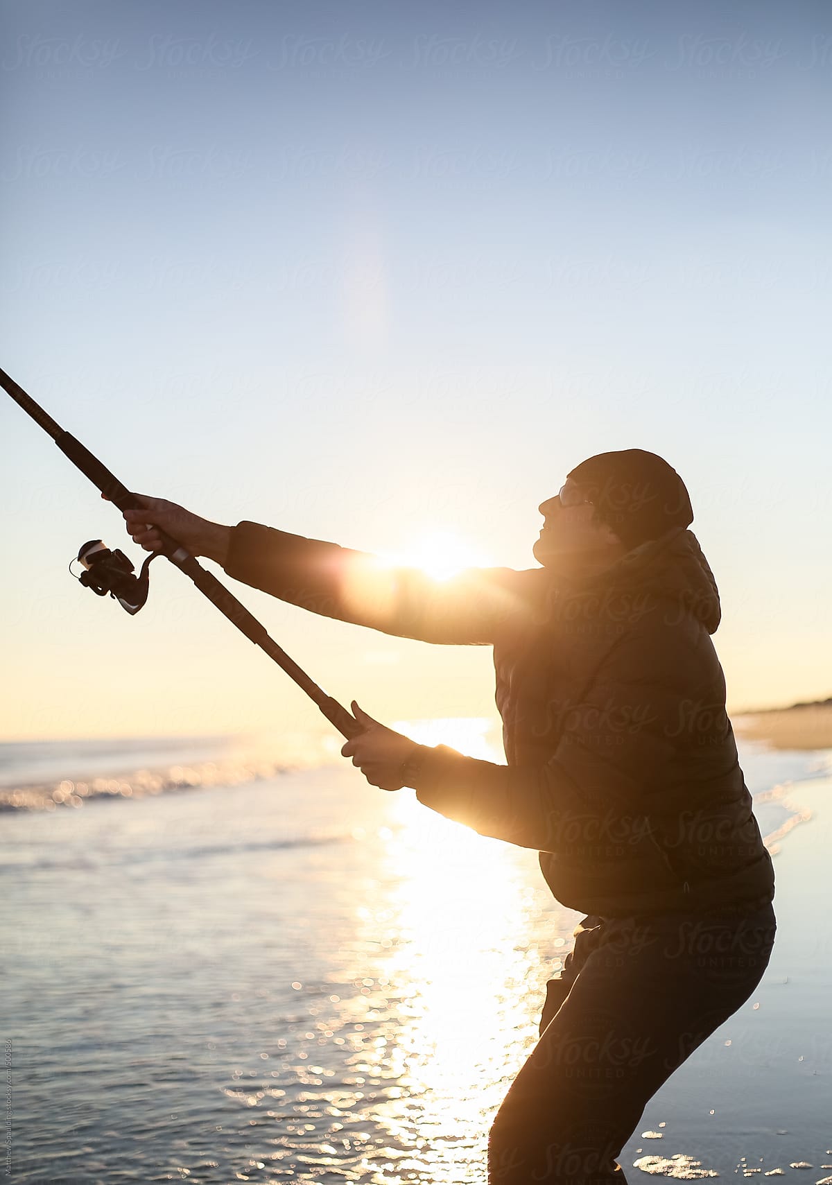Person Casting Fishing Pole To Catch Surf Fish On Atlantic Ocean