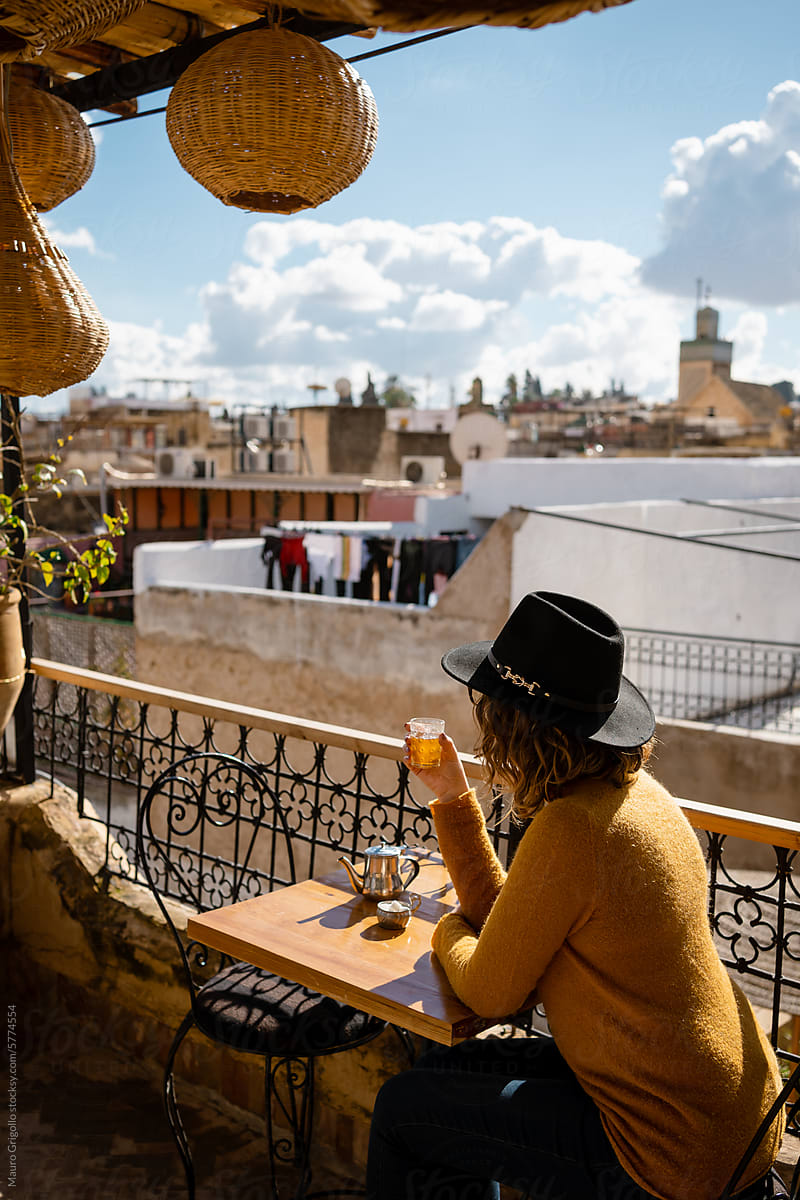 A woman sitting in a bar and drinking a Moroccan tea