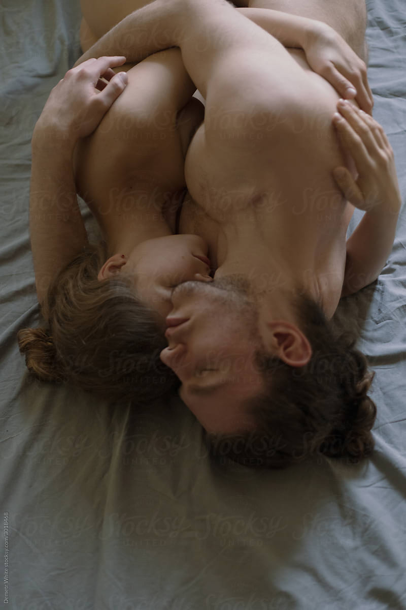 couple sleeping on bed in embrace