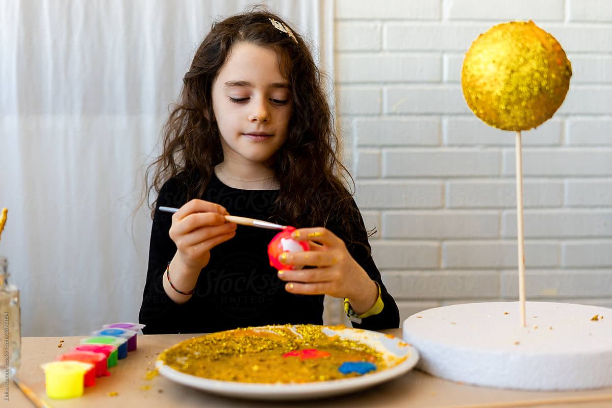 Young girl painting a handmade Solar System Craft For Science