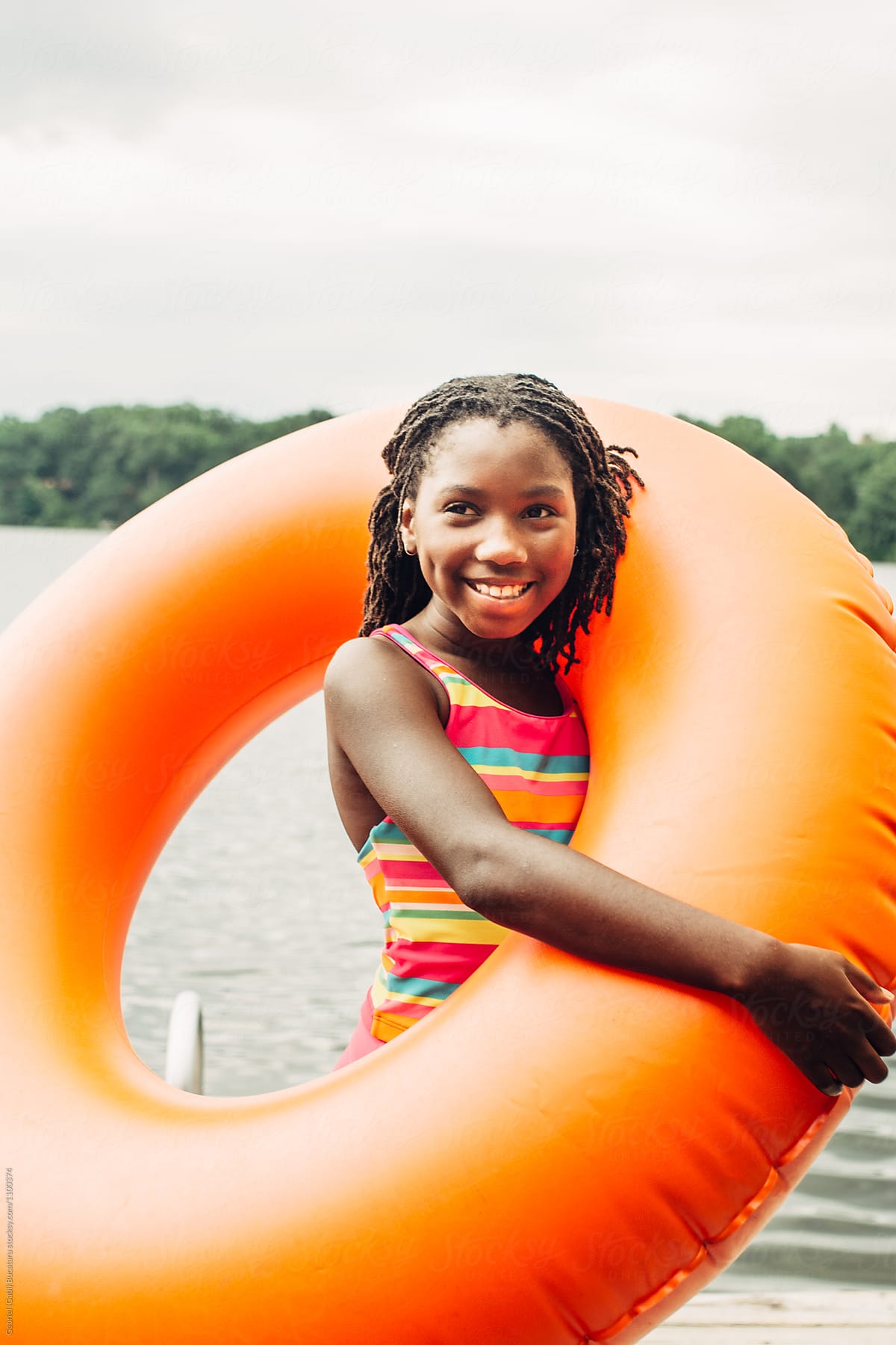 Smiling African American Girl With Orange Inner Tube By Stocksy Contributor Gabi Bucataru
