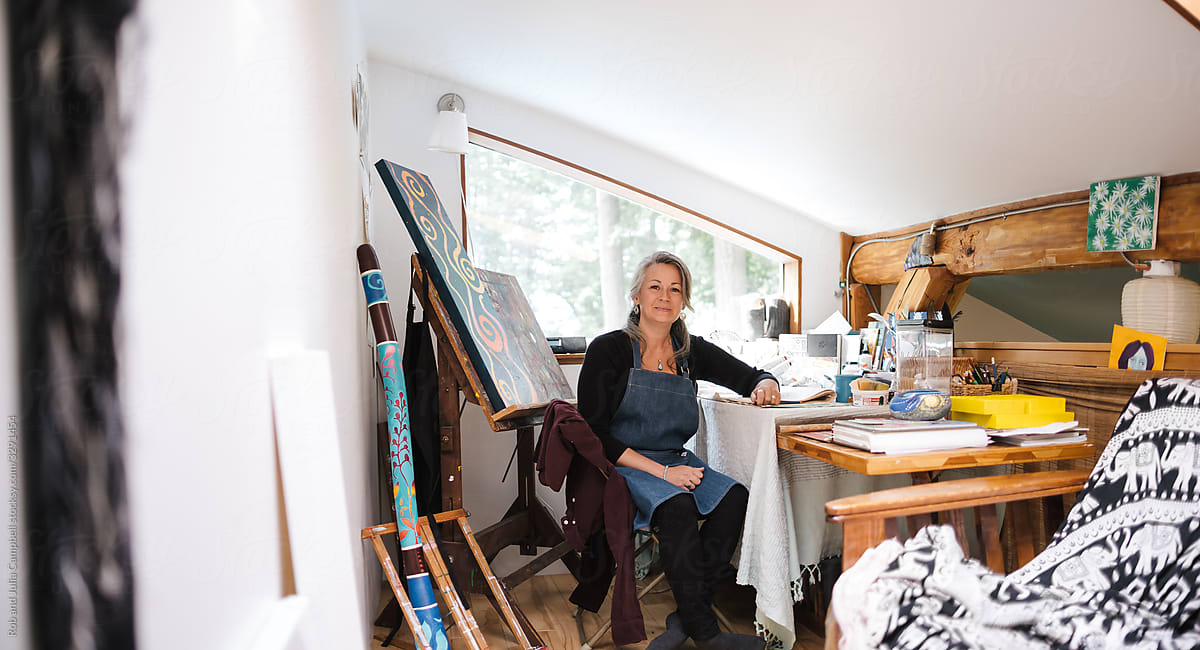 Mature woman portrait with art in her home loft studio.