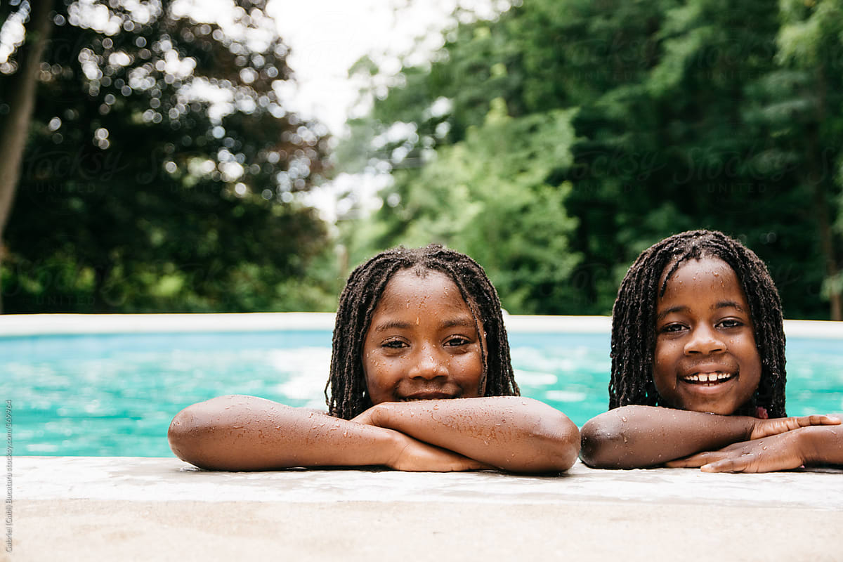 Two Black Girls By The Edge Of A Swimming Pool By Stocksy Contributor